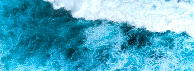 Fotobehang Tropisch Strand Banner Blue ocean Turquoise sea water white foam wave pattern splashing deep blue sea. Banner Tropical sea beach Seascape dark background splash on rock. Summer Ocean Surface wave with copy space  © aFotostock