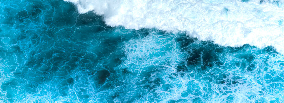 Banner Blue ocean Turquoise sea water white foam wave pattern splashing deep blue sea. Banner Tropical sea beach Seascape dark background splash on rock. Summer Ocean Surface wave with copy space
