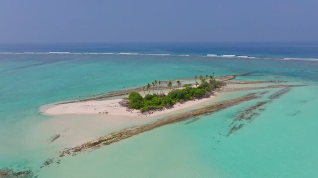 Aerial drone flight circling Innafinolhu local island in the Maldives featuring tropical beaches, turquoise lagoon and untouched island scenery in a peaceful setting.
