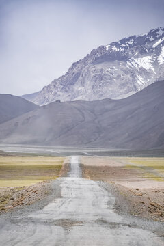 The Pamir Highway in the Tien Shan highlands of Tajikistan, a landscape with a road in the Pamirs, a road stretching into the distance against a backdrop of mountains