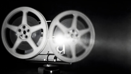 Fototapeta premium Vintage Movie Projector: A classic, vintage movie projector casts a bright beam of light, its reels of film spinning tales of bygone eras, creating a nostalgic atmosphere.