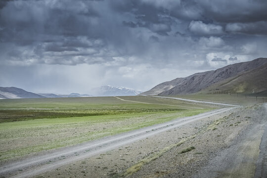 The Pamir Highway in the Tien Shan highlands of Tajikistan, a landscape with a road in the Pamirs, a road stretching into the distance against a backdrop of mountains