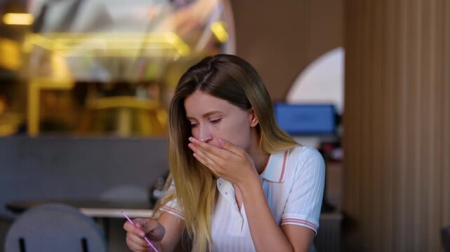 Caucasian female sitting in restaurant and eating bad meal. Food with no taste. Close up of beautiful young blonde woman having awful dish in cafe. Real time. Spicy food concept