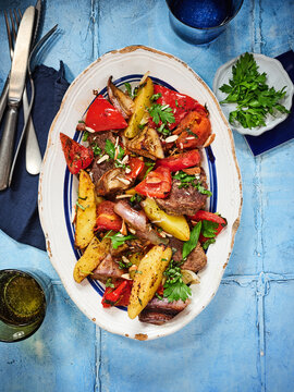 The dish showcases grilled beef alongside a colorful mix of roasted vegetables, arranged beautifully on a platter. Perfect for restaurant menus, food blogs, or summer gatherings