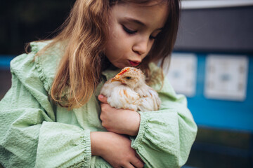 Girl taking care of chicken in family farm. © Halfpoint