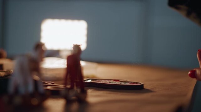 Caucasian hands dusting christmas cookie under backlight, sugar falling over gingerbread, miniature figurines in blurred foreground, bright bokeh panel, warm ambient glow, closeup tabletop decoration,