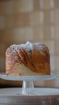 Slow motion rotating shot of a fresh cruffin on a glass cake stand