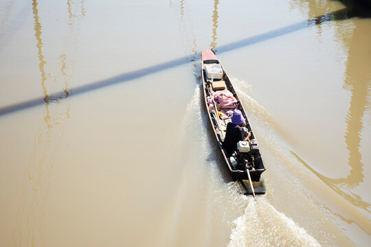 Life Lifestyle local thai people and old man drive sailing antique wooden boat longtail Canal of Community Village in Hua Takhe Old Market or Hua Ta Khe Bazaar at Lat Krabang city in Bangkok, Thailand