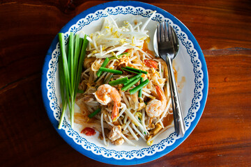 Traditional thai street food Pad Thai or Padthai cuisine meal thai style stir fried rice noodles with egg and vegetable mix spices sauce and shrimp at local restaurant cafe shop in Bangkok, Thailand © Anirut