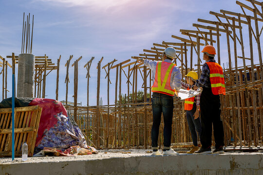 Structural engineer, architect and foreman worker with blueprints discuss, plan working for the outdoors building construction site. Construction collaboration concept