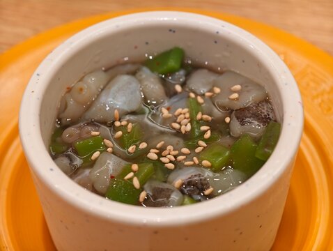Tako Wasabi (raw octopus with wasabi) topped with sesame seeds. Japanese cold dish