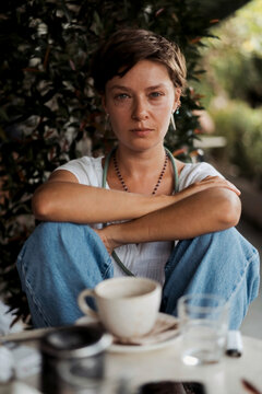 Resilient woman sitting alone outdoors looking directly at camera