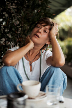 Woman experiencing burnout moment sitting alone outdoors with coffee
