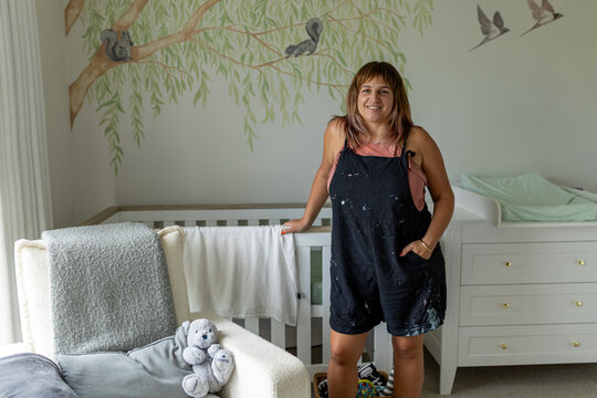 Artist in front of nursery mural