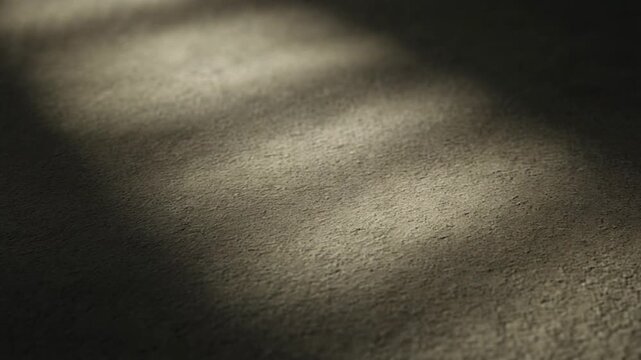 Abstract interplay of bright sunlight and deep shadows creating dynamic diagonal patterns on a textured surface, evoking a sense of calm contemplation and depth within an indoor setting