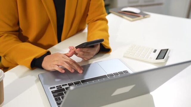 woman working on laptop and accounting financial report, accountant using calculator to calculate tax refund at office.