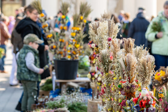 Buying verbos, traditional handcrafted decorations made from dried flowers and plants, in an outdoor market near the cathedral in Vilnius, Lithuania on Palm Sunday