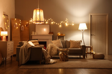Obraz premium Interior of living room with sofas, fireplace and glowing lights at night