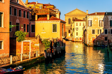 romantic view of a canal in Venice with boats and blue water and beautiful vintage buildings around the cityscape © Yaroslav