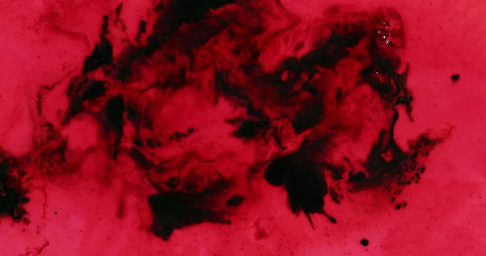 Red liquid with dark splotches swirling extremely slowly.