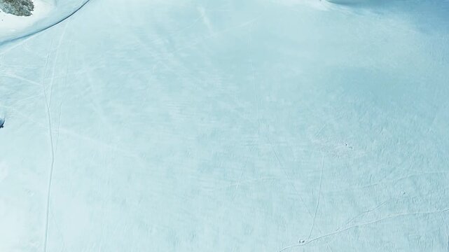 Cinematic drone reveal from white snow to a vast rugged valley in Chamonix, French Alps. Stunning high altitude winter landscape panorama of the Mont Blanc massif
