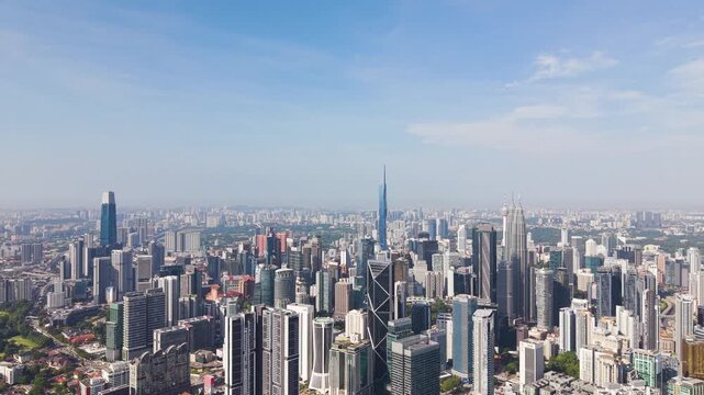 Push up aeria shot of Kuala Lumpur skyline featuring KLCC dense high-rise buildings, modern infrastructure, and vibrant urban landscape under clear daylight. UHD.