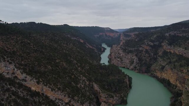High-altitude 4K drone panorama of the J&uacute;car River valley and the Spanish plateau. Wide aerial shot of dense pine forests, rocky escarpments, and distant horizons.