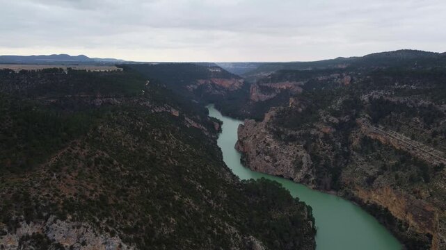 High-altitude 4K drone panorama of the J&uacute;car River valley and the Spanish plateau. Wide aerial shot of dense pine forests, rocky escarpments, and distant horizons.