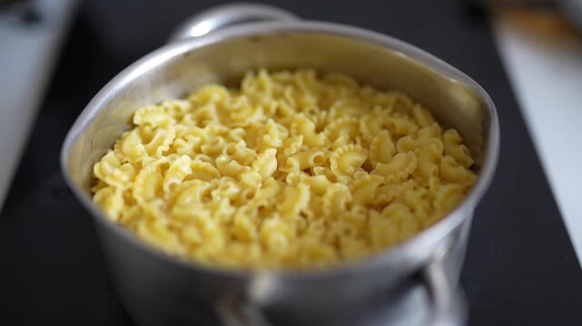 Cooked creste di gallo pasta served in a metal pot 