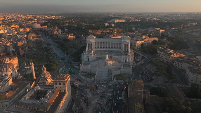 Monumento a Vittorio Emanuele II Aerial drone view in Rome Italy with moving traffic, historic avenues and warm golden hour light over the city center and surrounding monuments.