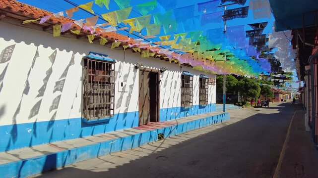 A view of Choroni's colonial architecture on a sunny day, with colorful pennants hanging in the breeze, Aragua, Venezuela