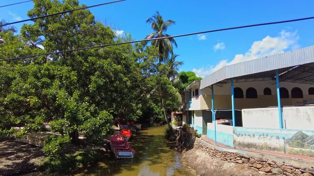 A still view of a small pier on a calm river with transport and fishing boats on the Choroni River, Aragua, Venezuela