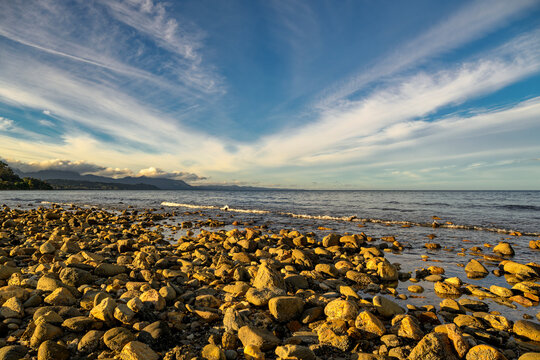 Rocky beach shoreline glowing with sunset light