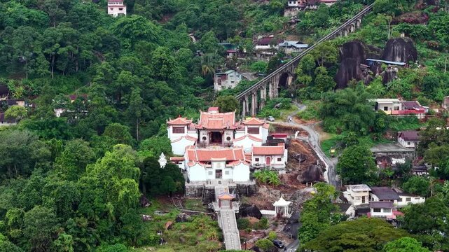 Aerial drone image showing Penang Hill funicular railway, hillside temple, surrounding forested settlement.