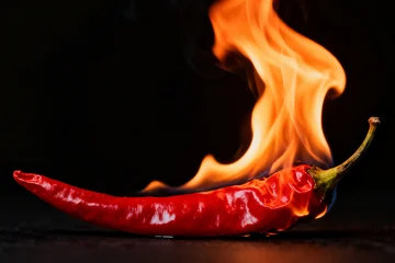 Keuken achterwand Hete pepers Burning red chilli against black background  © Mirko