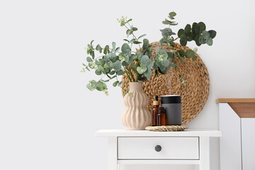 Air humidifier, essential oils and vase with eucalyptus on table in bedroom © Pixel-Shot