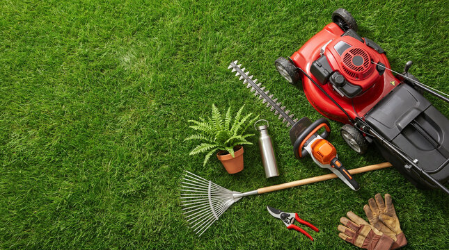 Gardening tools and equipment arranged on green grass background  