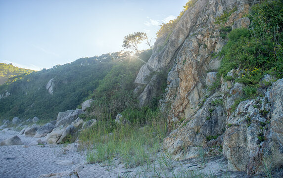 The coast of the Sea of Japan with coastal water-worn rocks, beach scarp. klip, rocky islets (skerry), seacoast erosion, Eastern Siberia, Primorsky Krai