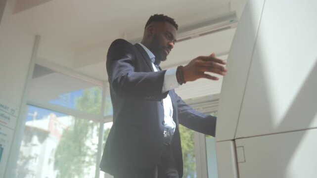 Diligent bank professional in formal attire conducts thorough security checks at ATM during daylight hours