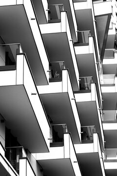 Exterior architecture in monochrome shows modern apartment building facade where balcony geometry and pattern create a graphic rhythm