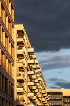 Sunset clouds color urban exterior architecture with modern apartment building facade where balcony details meet evening sky today