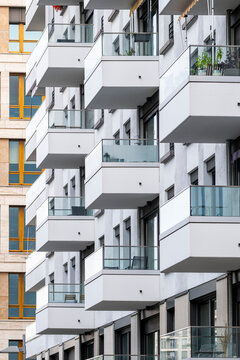 Urban exterior architecture captures modern apartment building facade where balcony windows create a rhythmic pattern on the residential skyline