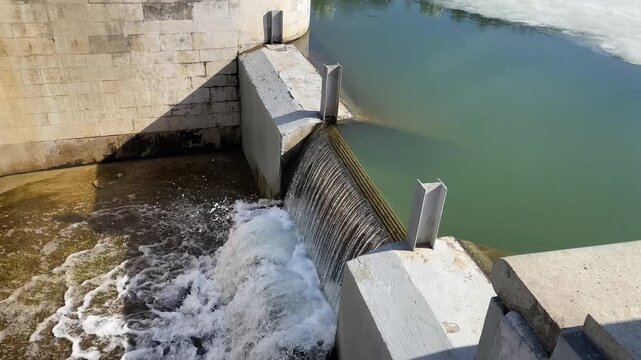 Sheet of water flowing over the weir. Active melting of ice, spring flood. Flashboard Dam. Water level control structure or Stop log structure.