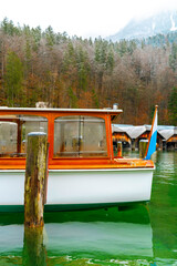 Fototapeta premium Boat at Königssee docking area with forested mountains