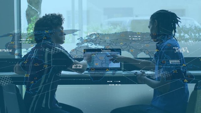 Vertical video: Two men working, right man pointing laptop starting HUD map, analyzing tech data