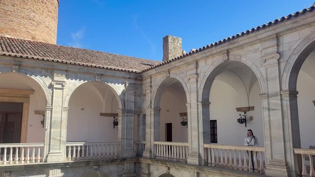 Parador de Zafra courtyard arches glow under bright daylight in Spain.