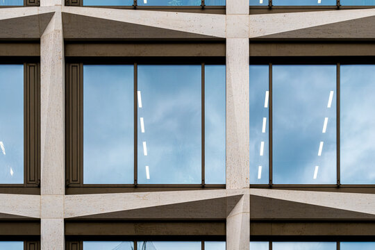 Concrete frame around office windows on modern building facade meets open sky creating minimal architecture pattern with geometric structure and calm