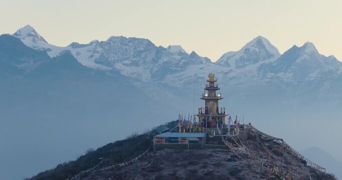 Aerial drone shot capturing the Buddhist monument and colorful prayer flags at Ama Yangri viewpoint in Helambu Nepal overlooking the majestic Gauri Shankar Himalayan range.