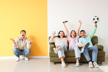 Naklejka premium Young man suffering from loud neighbours watching sport game at home