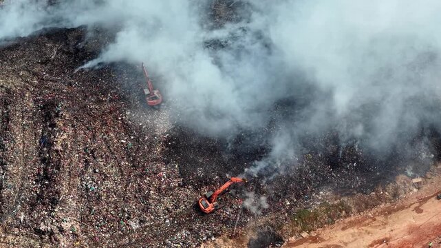 Aerial view of landfill fire with excavators operating on site